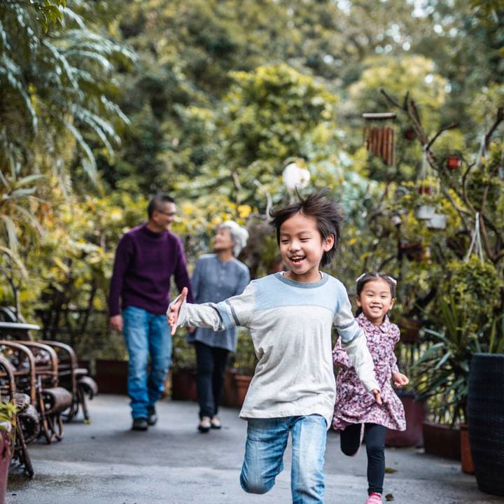 A little boy running in front of his parents