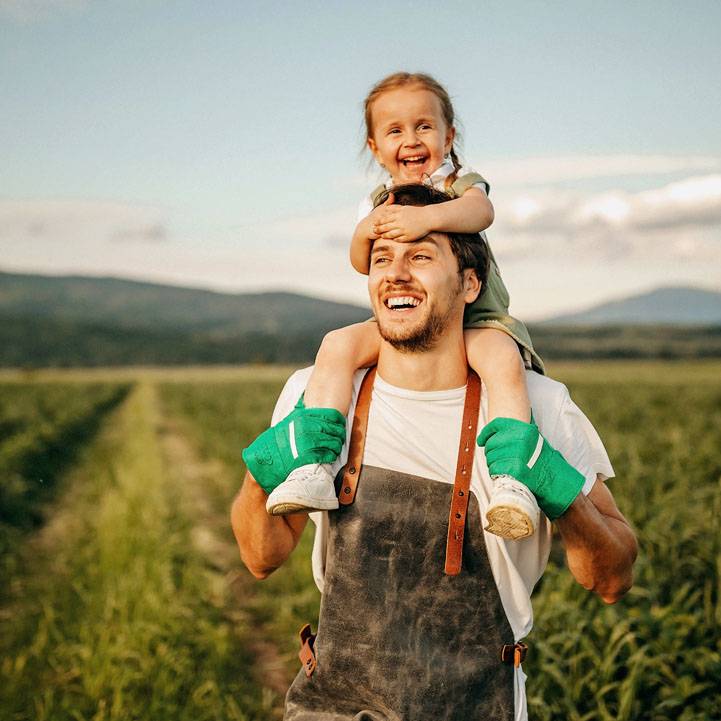 Father carrying his daughter on the famr land