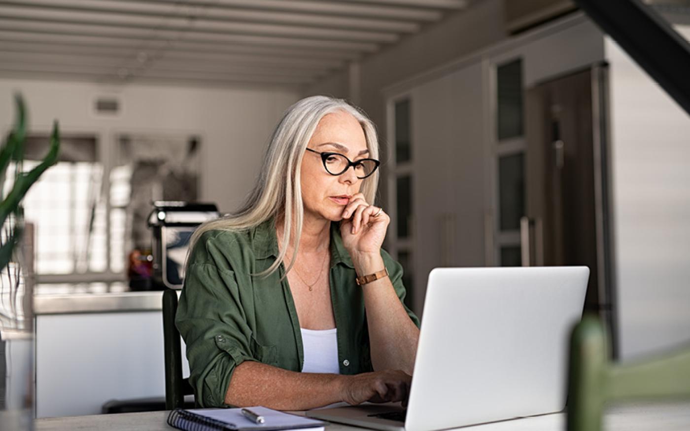 Woman thinking by the laptop